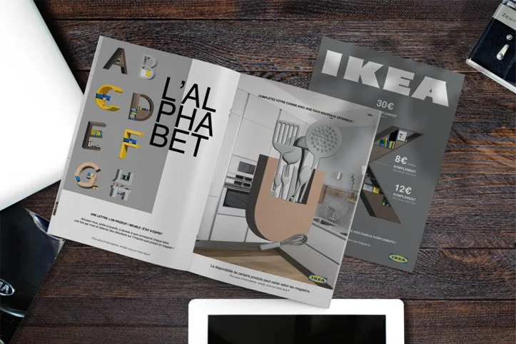 alt="Magazine IKEA avec les lettres de l'alphabet, posé sur un bureau"